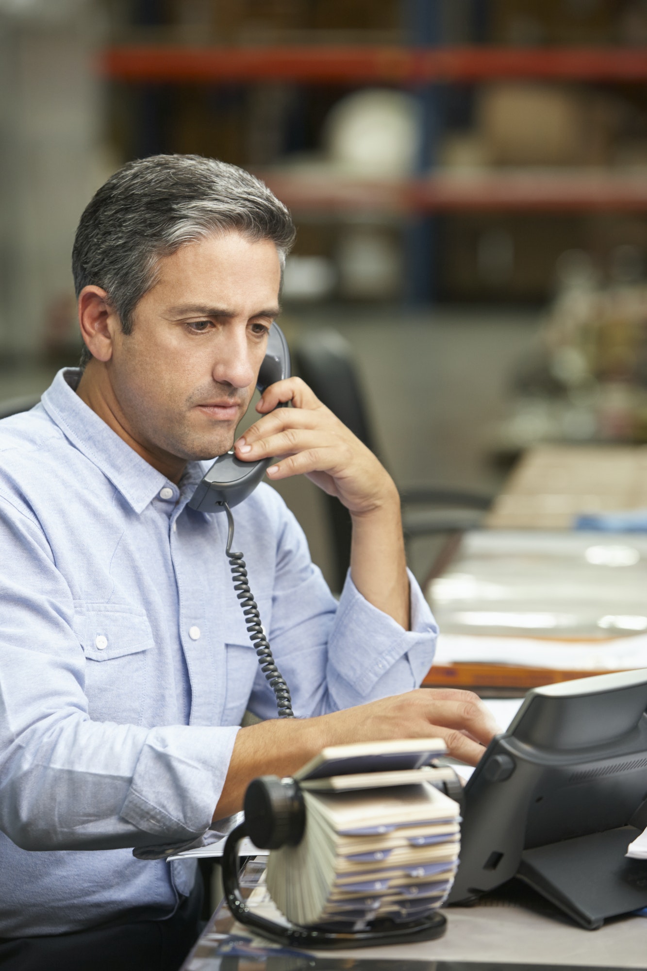 Manager Working At Desk In Warehouse